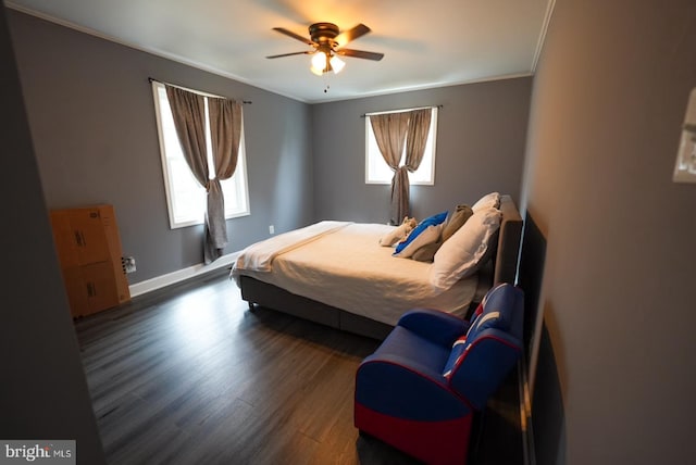 bedroom featuring crown molding, wood finished floors, baseboards, and ceiling fan