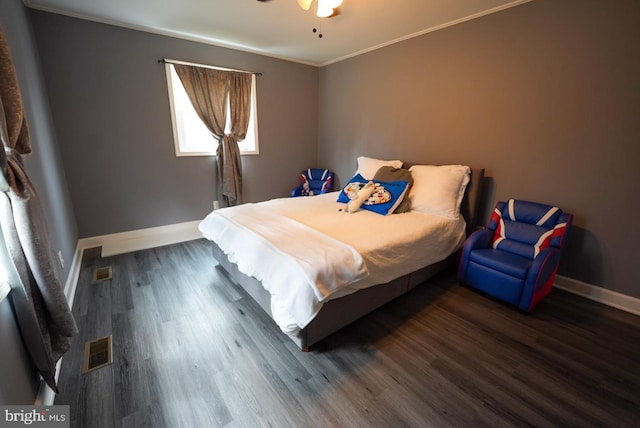 bedroom with visible vents, baseboards, wood finished floors, and ornamental molding