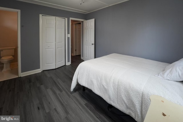 bedroom with dark wood-style floors, baseboards, crown molding, and a closet