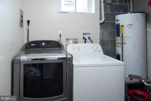 clothes washing area featuring laundry area, concrete block wall, separate washer and dryer, and water heater