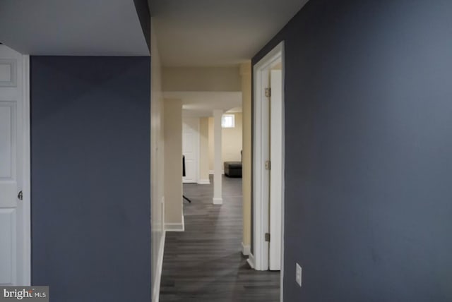 hall with dark wood-type flooring and baseboards