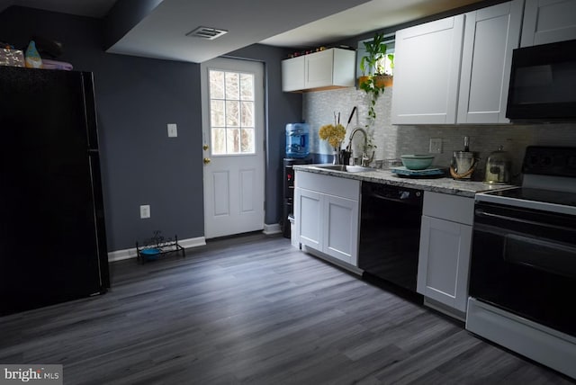 kitchen featuring visible vents, dark wood finished floors, a sink, black appliances, and tasteful backsplash