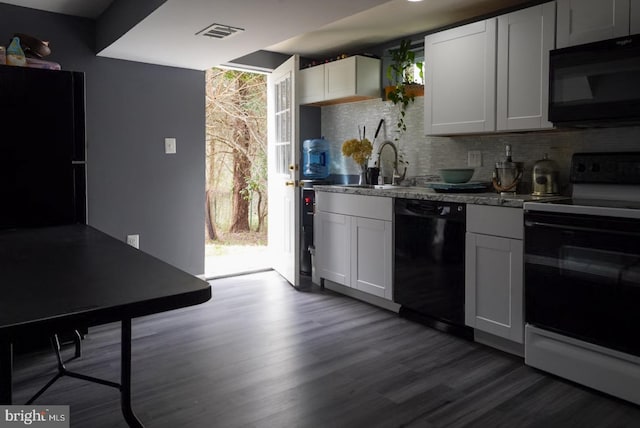 kitchen with dark wood-style floors, visible vents, a sink, black appliances, and backsplash