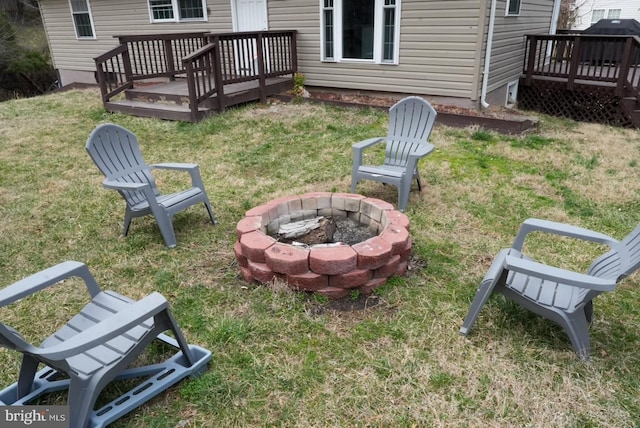 view of yard with a wooden deck and an outdoor fire pit