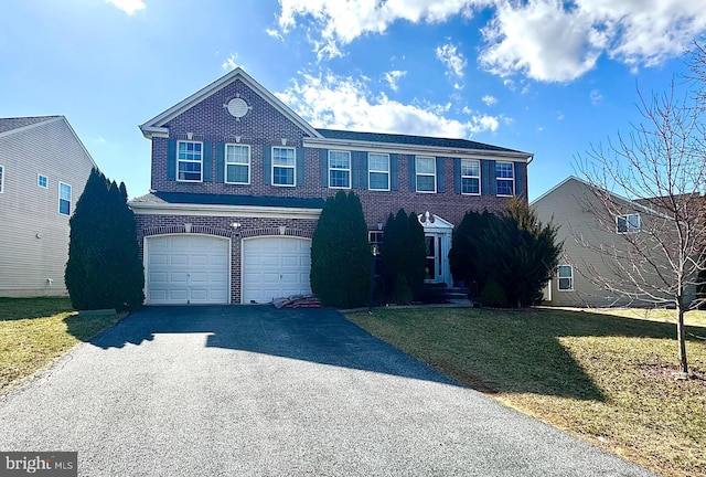 view of front of property featuring brick siding, driveway, a front lawn, and a garage