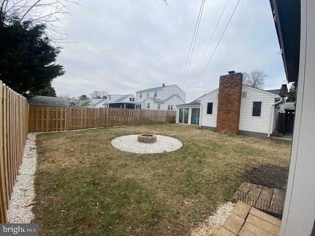 view of yard with a fenced backyard and an outdoor fire pit