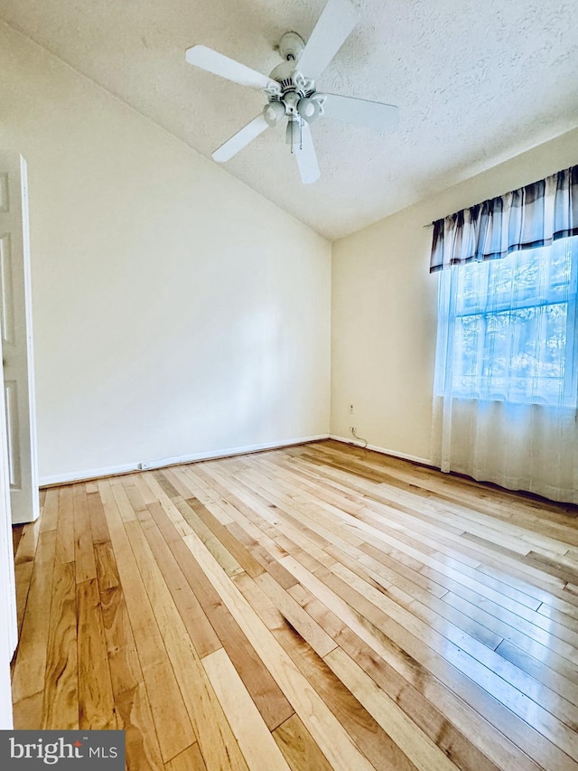 empty room featuring hardwood / wood-style flooring, a ceiling fan, and a textured ceiling