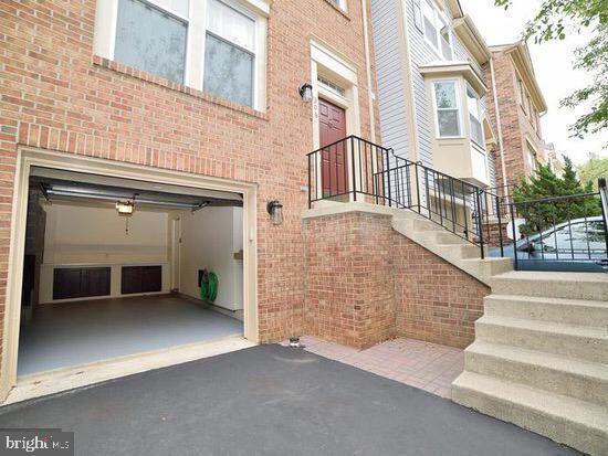 view of exterior entry featuring brick siding, driveway, and a garage