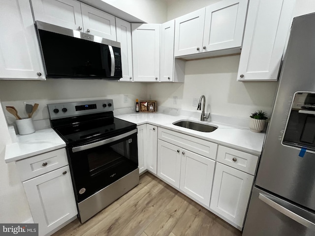 kitchen featuring a sink, stainless steel appliances, and white cabinets