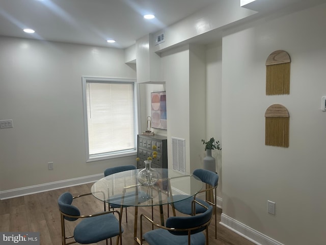 dining area with wood finished floors, visible vents, and baseboards