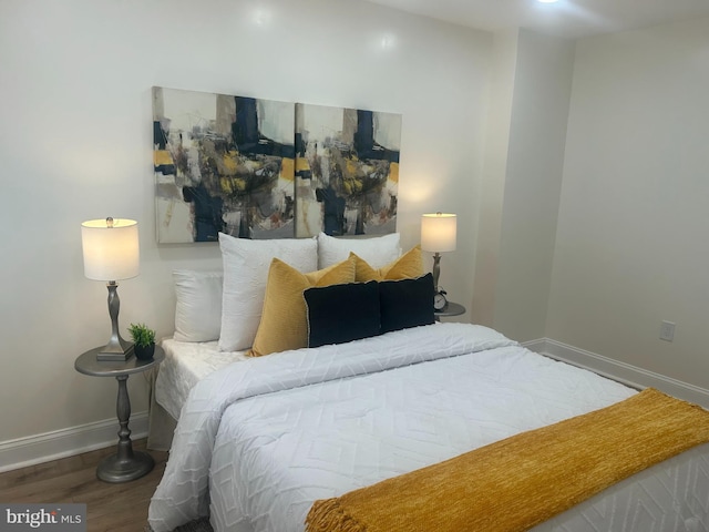 bedroom with baseboards and wood finished floors