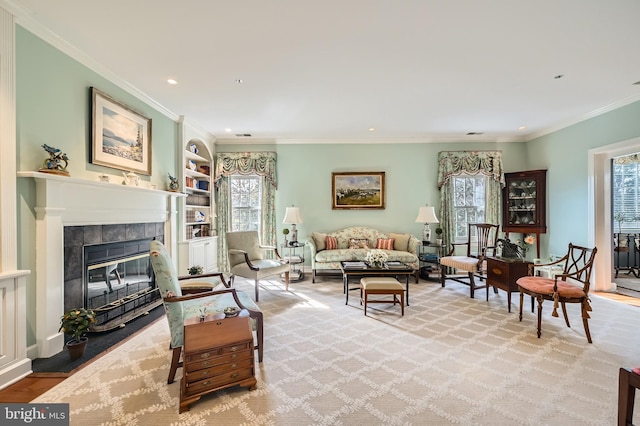 living room featuring recessed lighting, a tile fireplace, built in shelves, and ornamental molding