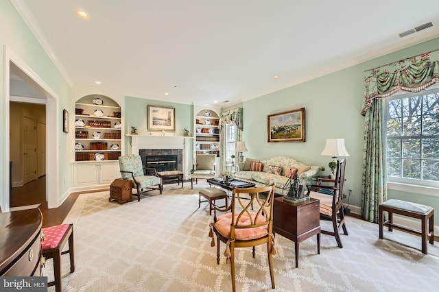 living area featuring built in features, baseboards, visible vents, a tiled fireplace, and crown molding