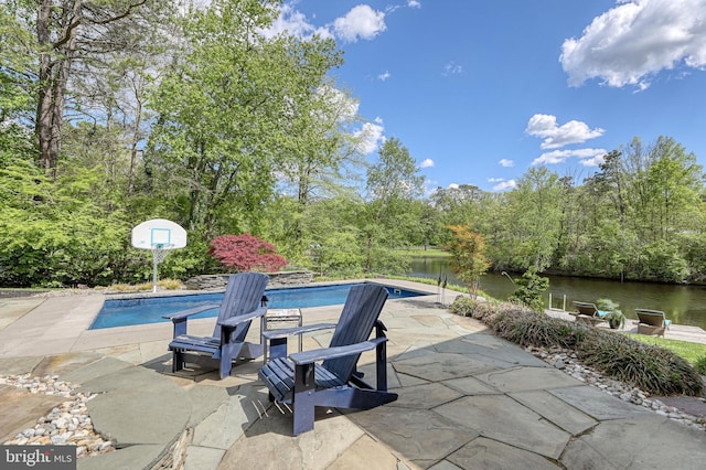 outdoor pool with a patio area and a water view