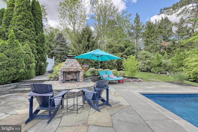 view of patio with an outdoor pool and an outdoor stone fireplace