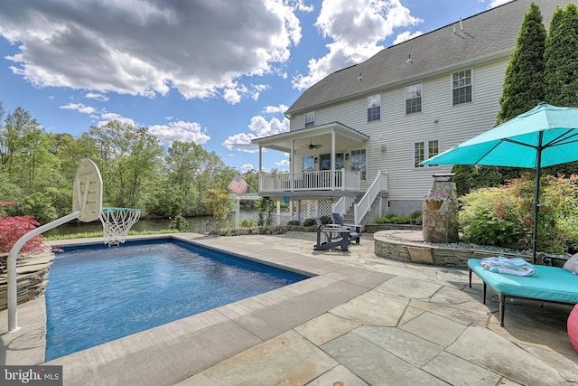 outdoor pool featuring a ceiling fan, stairs, and a patio area