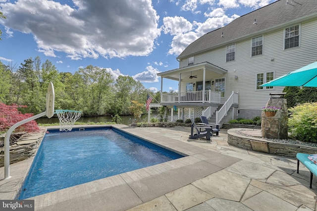 pool with a ceiling fan, stairway, and a patio area