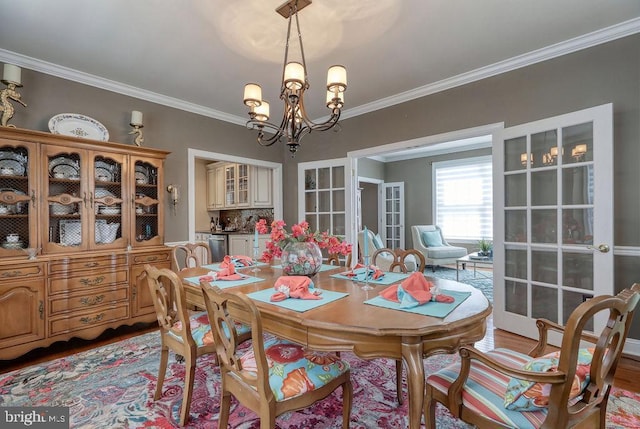 dining space featuring ornamental molding, wood finished floors, and a chandelier