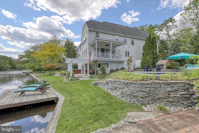 back of house featuring a yard, a patio, ceiling fan, and a water view