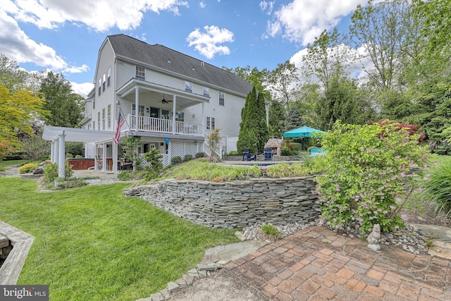 back of house featuring a patio, a lawn, and a ceiling fan