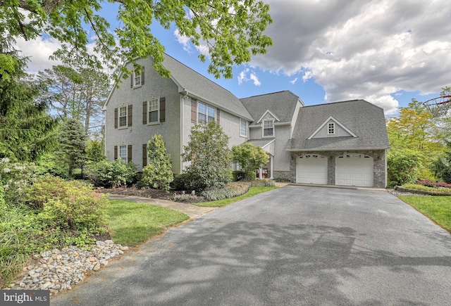 view of front facade with stone siding and driveway