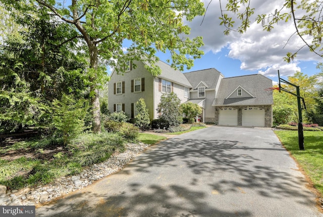 view of front facade featuring aphalt driveway, a garage, and stucco siding