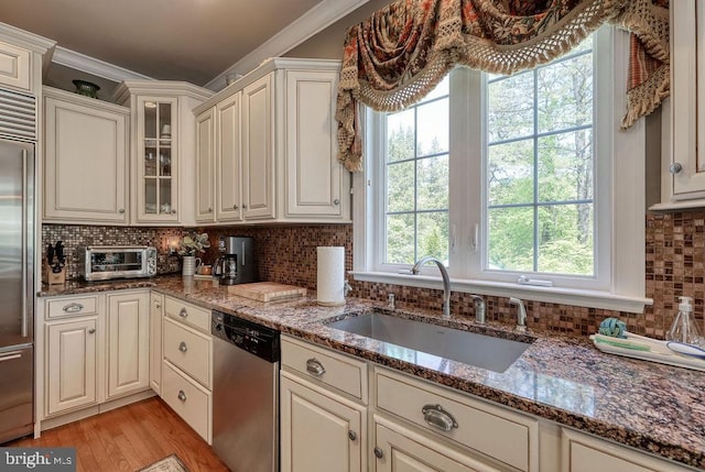 kitchen with a sink, stainless steel appliances, decorative backsplash, and a toaster