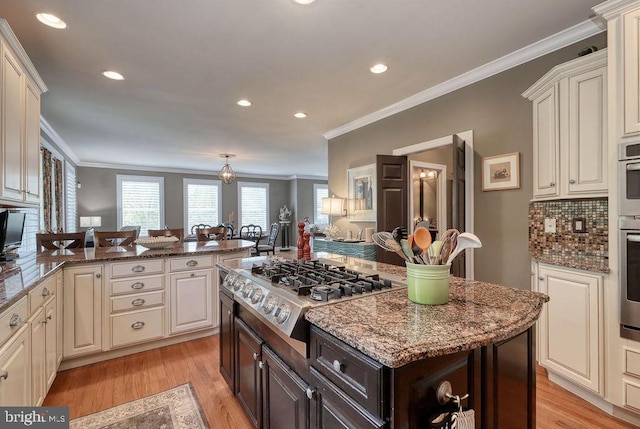 kitchen featuring dark brown cabinets, appliances with stainless steel finishes, light wood-type flooring, and ornamental molding