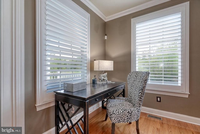 office area featuring visible vents, baseboards, wood finished floors, and crown molding