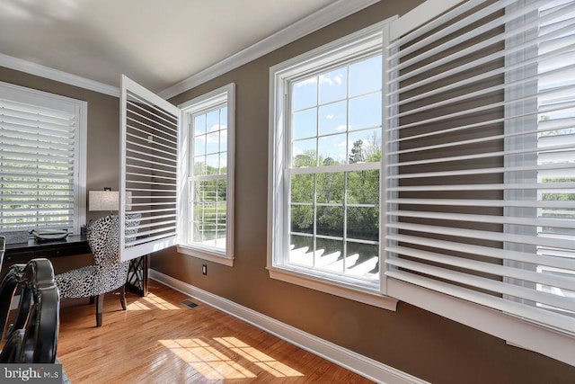 home office featuring visible vents, baseboards, crown molding, and light wood finished floors