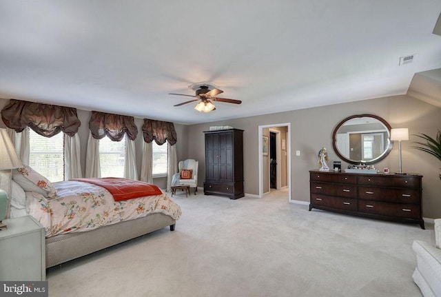 bedroom featuring visible vents, baseboards, light colored carpet, and a ceiling fan