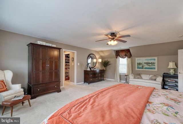 bedroom featuring a ceiling fan, a spacious closet, light colored carpet, and baseboards