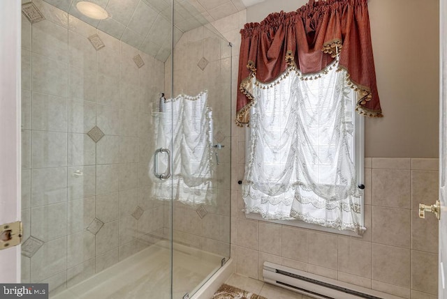 bathroom with baseboard heating, tile walls, and a stall shower