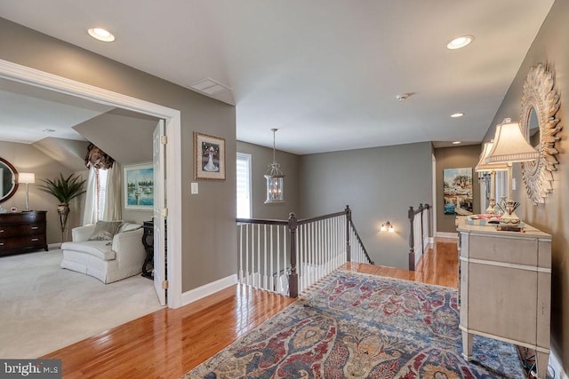 hallway featuring an upstairs landing, recessed lighting, light wood-type flooring, and baseboards