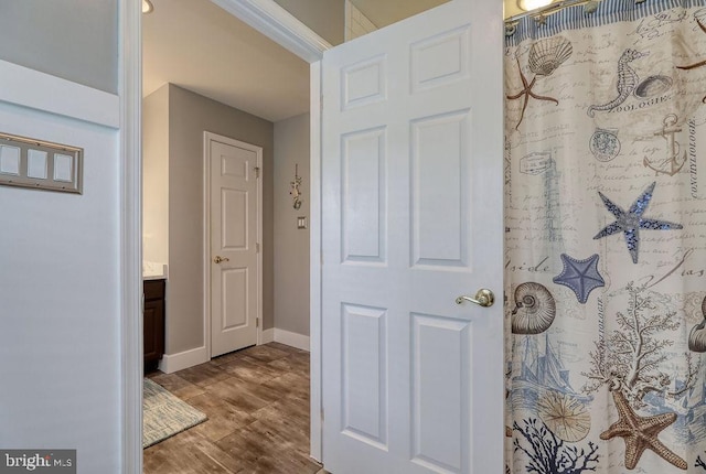 full bath with vanity, a shower with curtain, wood finished floors, and baseboards