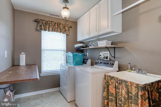 laundry area with visible vents, baseboards, separate washer and dryer, cabinet space, and a sink