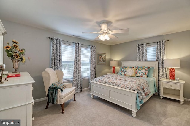 bedroom featuring multiple windows, light colored carpet, and baseboards