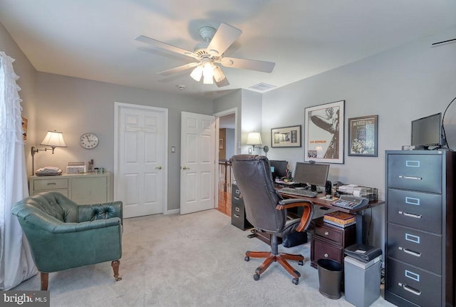 home office featuring light carpet, visible vents, and ceiling fan