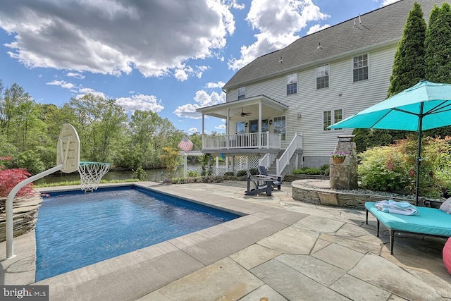 pool featuring a patio, ceiling fan, and stairs