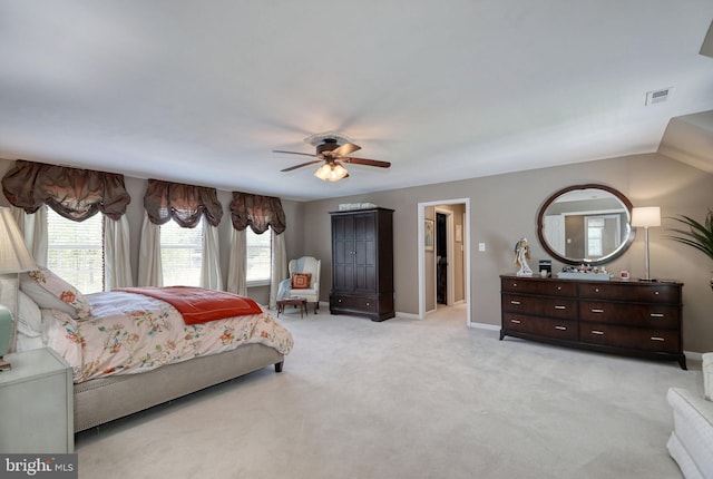 bedroom with a ceiling fan, baseboards, visible vents, and light carpet