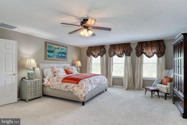 bedroom featuring a ceiling fan, light colored carpet, and visible vents