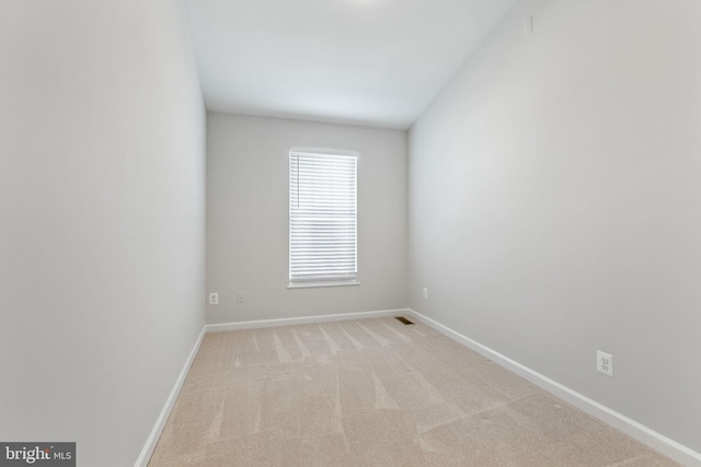 spare room featuring baseboards and carpet floors