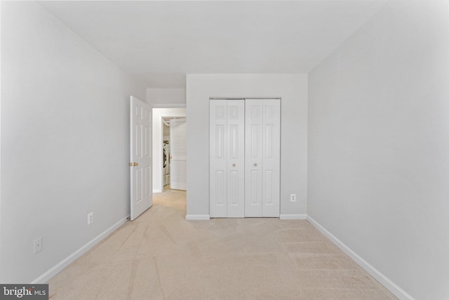 unfurnished bedroom featuring a closet, baseboards, and carpet floors