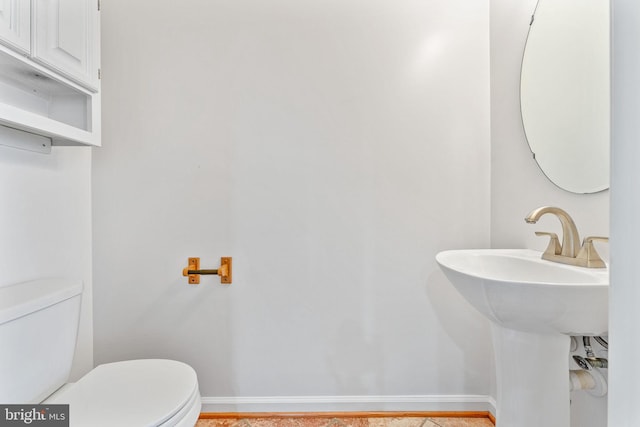 bathroom with toilet and baseboards