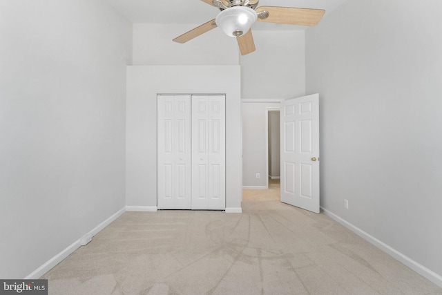 unfurnished bedroom with a high ceiling, carpet flooring, baseboards, and a closet