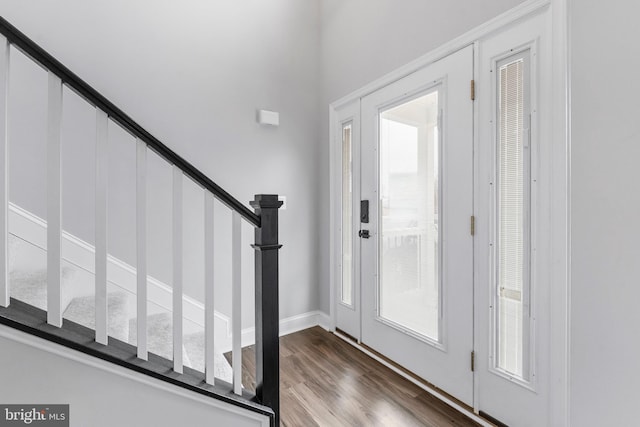 entryway featuring stairs, dark wood-style floors, baseboards, and a wealth of natural light