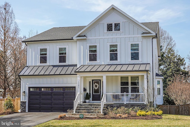 modern farmhouse style home featuring board and batten siding, concrete driveway, covered porch, metal roof, and a standing seam roof