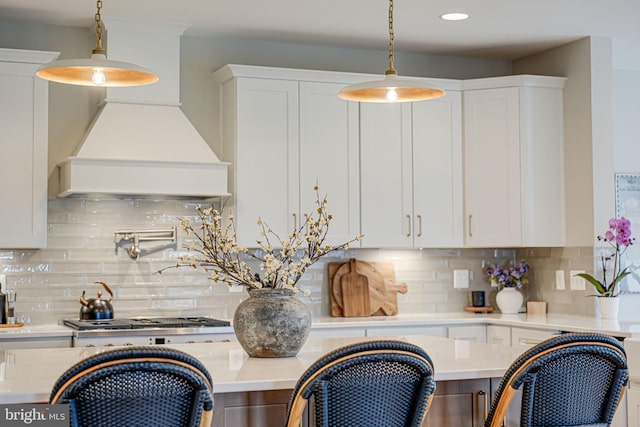 interior space featuring premium range hood, stainless steel gas cooktop, and light countertops