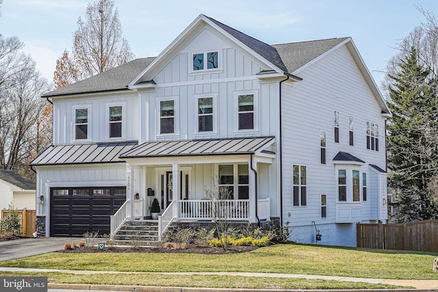 modern farmhouse style home with a porch, concrete driveway, fence, and board and batten siding