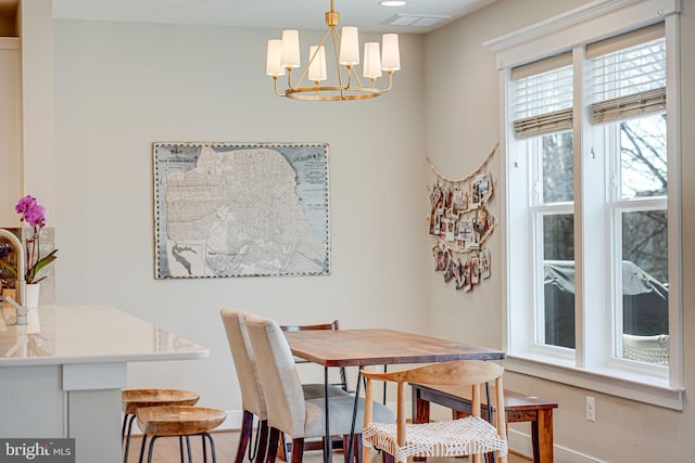 dining room featuring a chandelier, visible vents, and baseboards